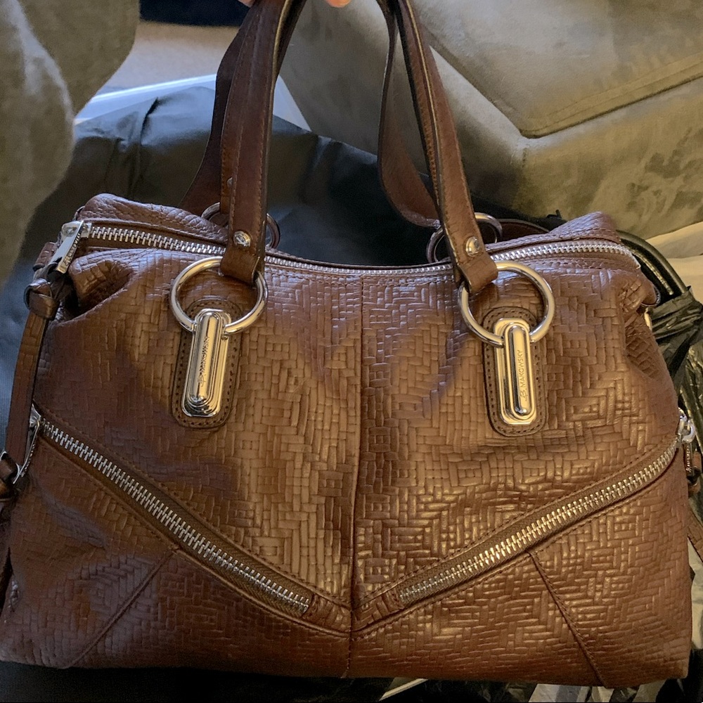 B Makowski leather purse with weave pattern and zippered pockets.